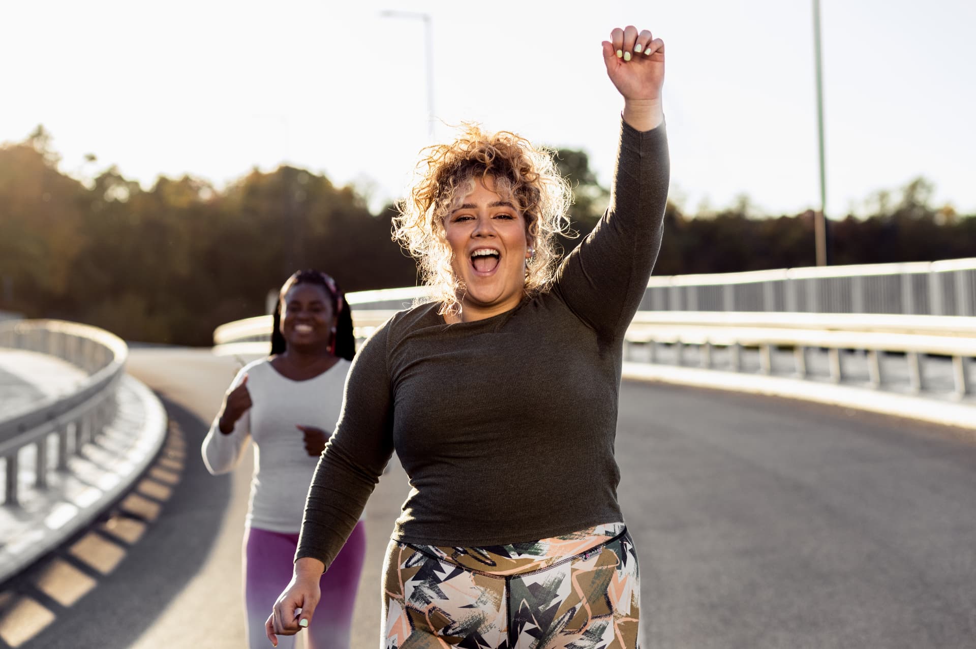 Dos mujeres corriendo al aire libre, sonrientes y llenas de energía